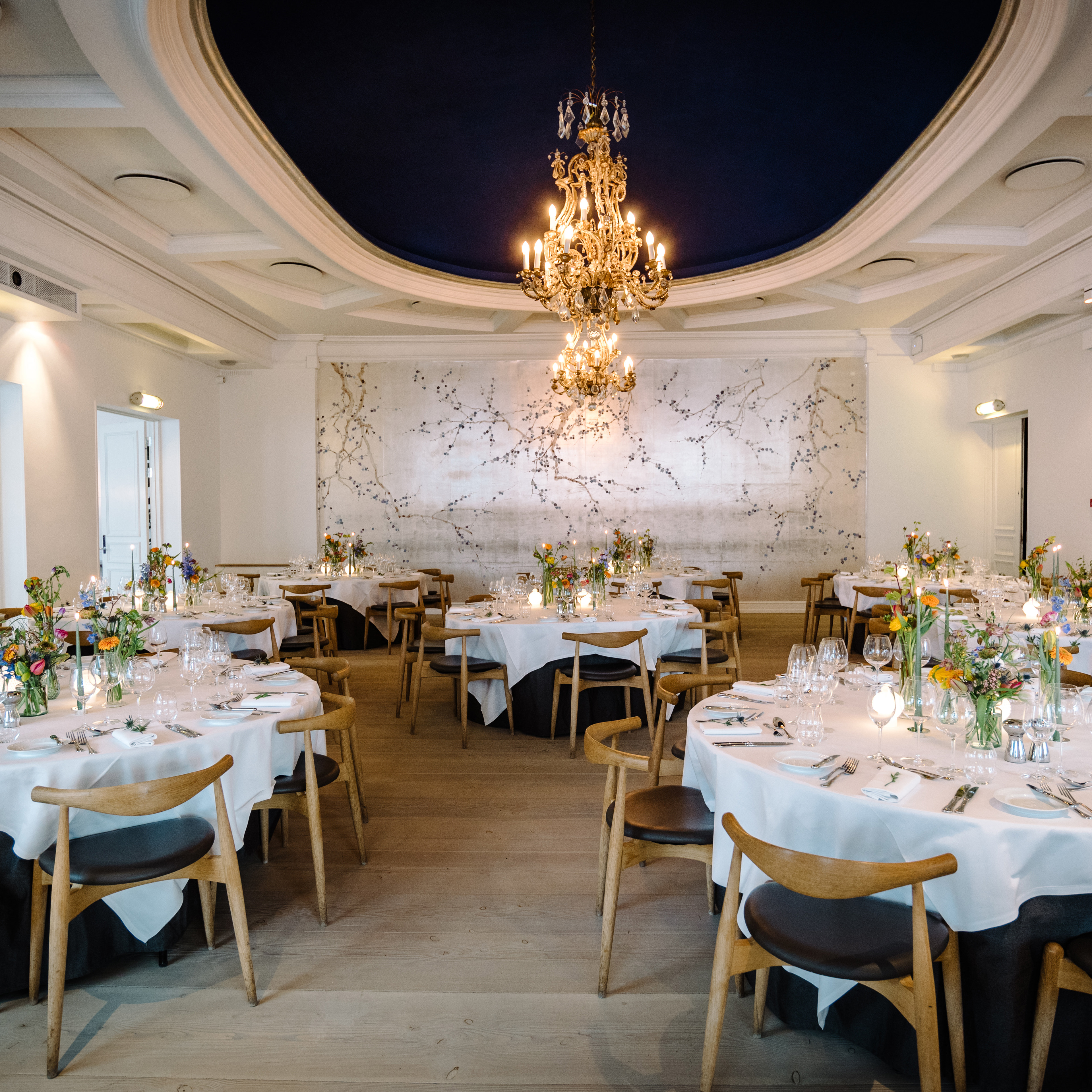 The Rotunda at Nimb, featuring beautifully set tables, floral arrangements and elegant chandeliers.